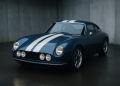 Blaues Retro-Coupé mit weißen Streifen und sechs Rundscheinwerfern in einer Betonhalle